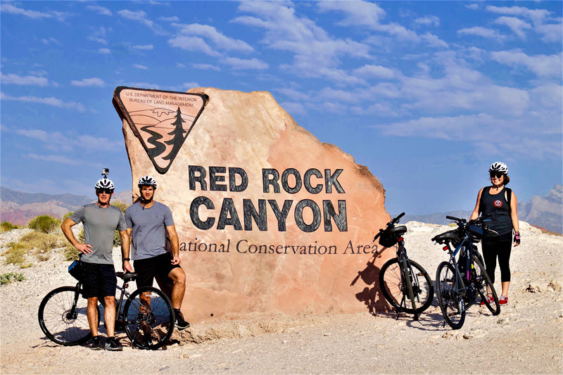 Group of riders posing with electric bikes at Red Rock Canyon overlook